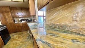 A kitchen with wooden cabinets, a granite countertop, a stove, and a microwave. - CLOSE TO DISNEYLAND & CONVENTION CENTER  (Anaheim)