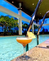 Una piscina al aire libre, sillones reclinables de piscina