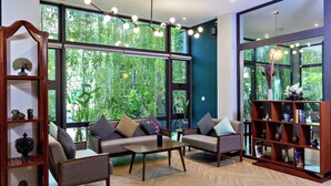 Een moderne woonkamer met grote ramen, een houten salontafel en een boekenkast.