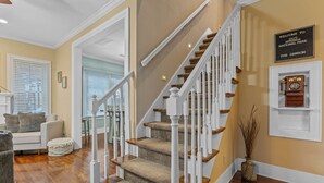 Een trap met witte balustrades en beklede treden, een bordje met de tekst 'Welkom bij Hot Springs National Park The Dawson', en een oude telefoon aan de muur.