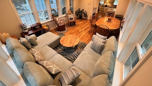 A spacious living area with a large sectional sofa, a wooden dining table, and a ceiling fan. - 4BD/2BA. Tranquil Cape Getaway for family  (Barnstable)