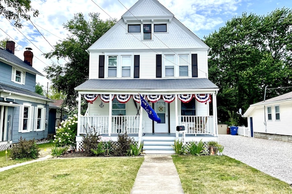 1920s, Victorian style home featuring a big front porch & patriotic bunting.
