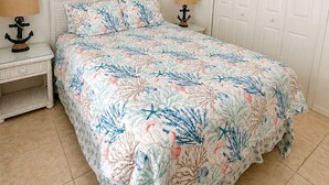 A bedroom with a bed, two bedside tables, a ceiling fan, and a door. - CHARMING FLORIDA GETAWAY 3BDR HOME WITH A POOL (Rotonda West)