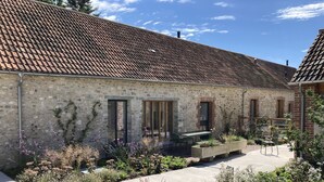 A stone building with a tiled roof, a garden with various plants, and outdoor seating. - Lookout -  Lower Wraxall, Cattistock (Dorchester)