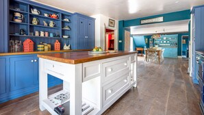 Una cocina con armarios azules, una encimera de madera y un cartel que dice 'LONDON BRIDGE'.
