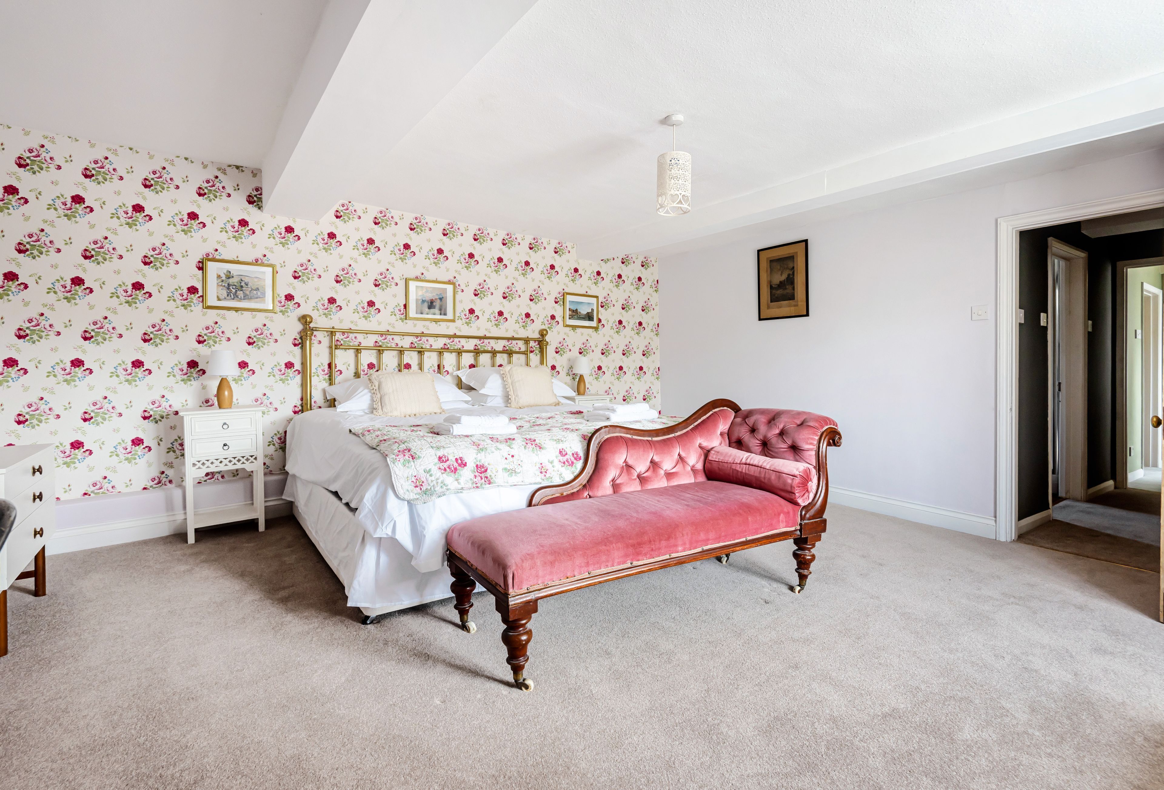 Ein Schlafzimmer mit einem Bett, einem Frisiertisch und einer Bank.