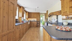 Una cocina amplia con armarios de madera, una encimera curva y vistas al exterior.