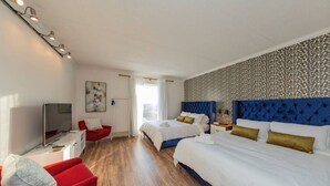 A hotel room with two beds, a TV, a red chair, and a patterned wall. - Music Row Retreat with Pool and Free Parking, Walk to Bars! (Nashville)