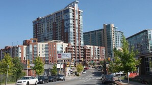 A multi-story building with a mix of residential and commercial spaces, featuring large windows and a prominent entrance. - Music Row Retreat with Pool and Free Parking, Walk to Bars! (Nashville)