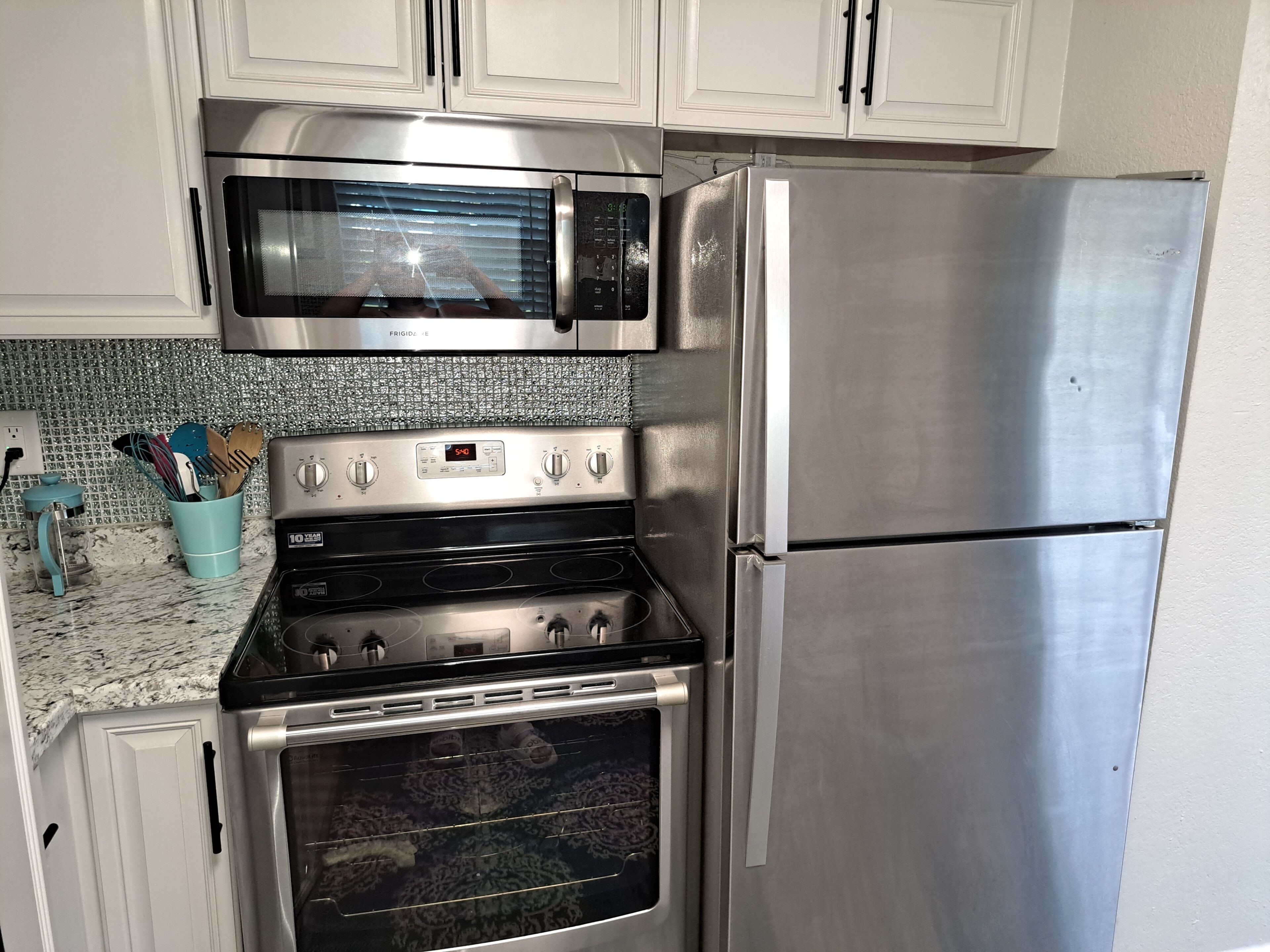 A kitchen with stainless steel appliances including a microwave, oven, and refrigerator.