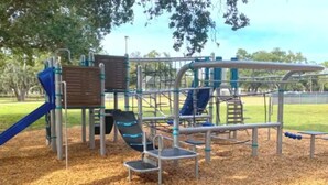 Un parque infantil con diversas estructuras de juego, incluyendo toboganes y zonas de escalada.