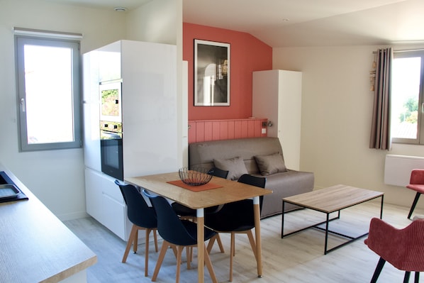 A compact living space with a kitchenette, a dining area, and a seating area.