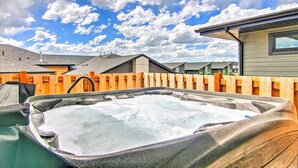 A hot tub in a backyard with a wooden fence and houses in the background. - Modern Bozeman Family Townhome w/ Hot Tub! (Bozeman)