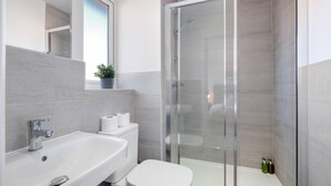 A modern bathroom with a glass-enclosed shower, a white sink, and a toilet. - Modern 5 Bedroom 3 Bath Hse Aylesbury (Aylesbury)