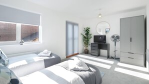 A modern bedroom with two beds, a TV, a wardrobe, and a potted plant. - Modern 5 Bedroom 3 Bath Hse Aylesbury (Aylesbury)
