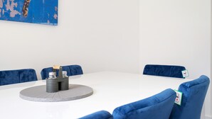 A conference room with a white table, two black candle holders, and blue velvet chairs. - Modern 5 Bedroom 3 Bath Hse Aylesbury (Aylesbury)