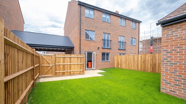 A residential property with a well-maintained lawn, a wooden fence, and a brick building with multiple windows. - Modern 5 Bedroom 3 Bath Hse Aylesbury (Aylesbury)