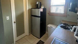 A compact kitchen with a refrigerator, stove, and a window with blinds. - Beautiful Studio Suite #4 (Loa)