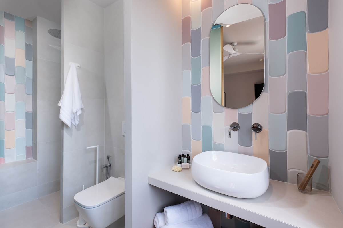 A modern bathroom with a toilet, a sink, and a shower.