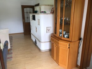 A compact kitchen with a refrigerator, wooden cabinet, and a rug.