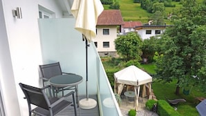 A balcony with a table and chairs, a tent, and a view of a green landscape. - Apart B by Interhome (Ried im Oberinntal)