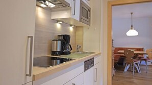 A modern kitchen with stainless steel appliances, a dishwasher, and a wooden countertop. - Apart B by Interhome (Ried im Oberinntal)