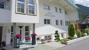 Ein weißes Gebäude mit einem grünen Dach und einem Schild mit der Aufschrift 'Appart abreszeiten'.