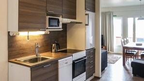 Una cucina moderna con forno a microonde, forno e lavastoviglie integrati, mobili in legno e un'ampia finestra che dà su un panorama esterno.