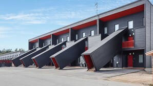 Un edificio moderno con più piani e un dettaglio rosso.