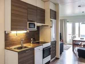 A modern kitchen with a microwave, sink, and oven. - Skivillas 47 ukkohalla (a7) by Interhome (Hyrynsalmi)