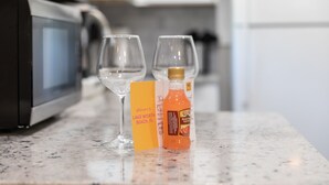 Una encimera de cocina con dos copas de vino, una botella de Ruby Red Margarita y una tarjeta amarilla.