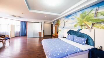 Un dormitorio amplio con una cama grande, un mural de palmeras en la pared y suelo de madera.