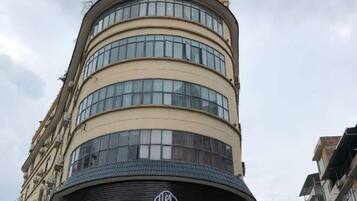 A multi-story building with a curved facade and a prominent logo at the base.