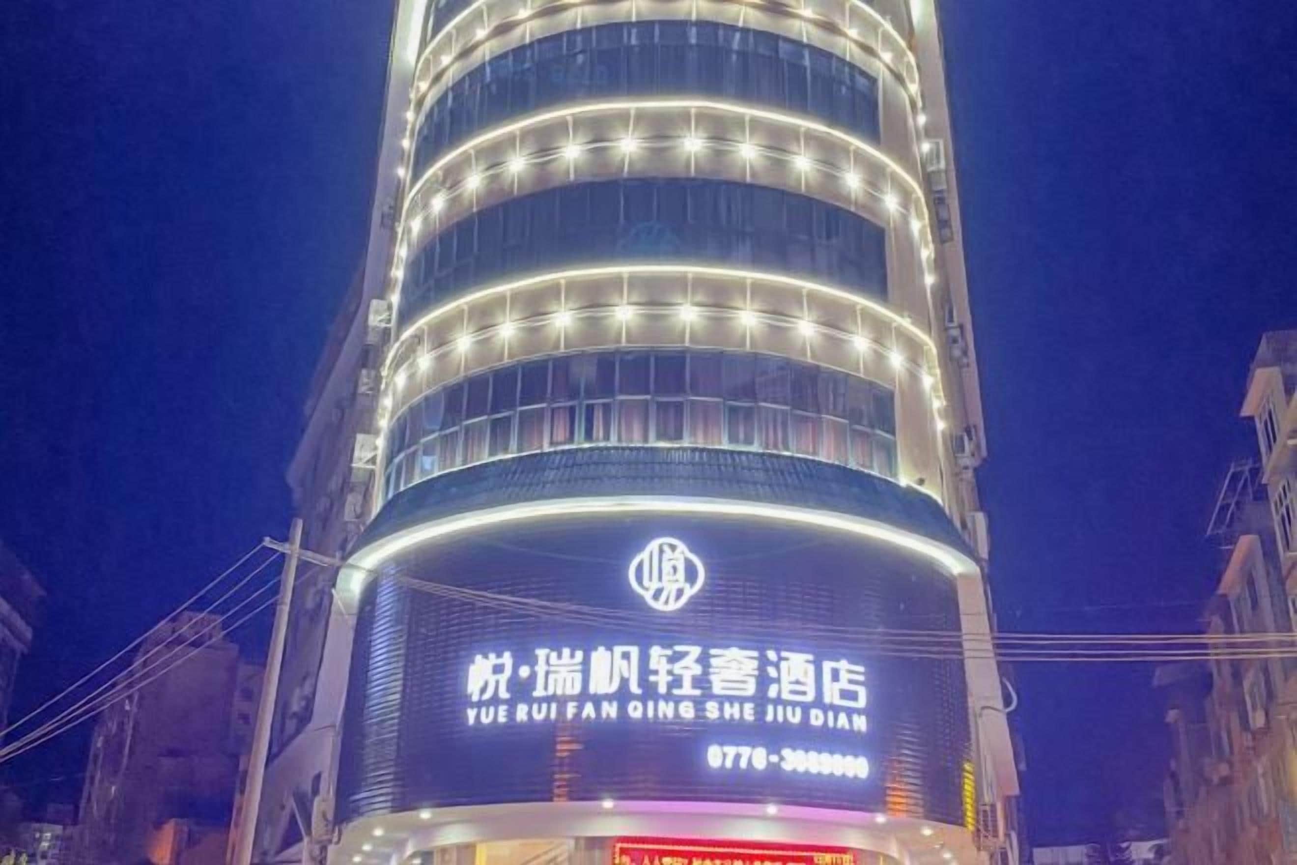Un hôtel doté d’une enseigne lumineuse bien visible, de plusieurs étages et d’une architecture moderne.