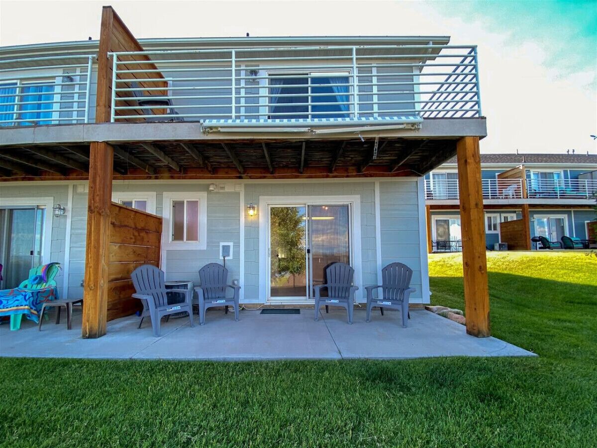 Un bâtiment à deux étages doté d’un patio couvert, d’un espace extérieur aménagé pour s’asseoir et offrant une vue sur le quartier environnant.