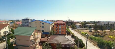 A residential area with multi-story buildings, a street, and a crane in the distance.