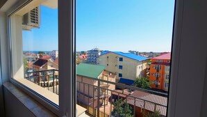 Vista desde una ventana a una zona residencial con diversos edificios y cielo despejado.