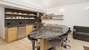 A modern kitchen with a marble island, wooden cabinets, and built-in shelves. - Fifth Avenue Unit 5 | Modern & Stylish Condo with A/C and Access to Pool & Hot Tub (Aspen)