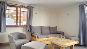 A modern living room with a sofa, two armchairs, and a wooden coffee table. - Comfort & Sauna, Hammam, WIFI, 8 pers, Near slopes (Les Menuires)
