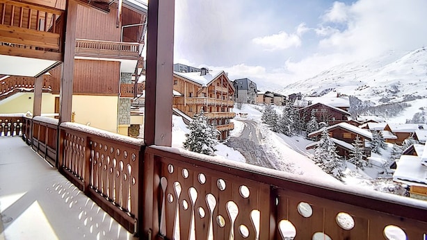 A wooden balcony with a view of a snow-covered village and mountains. - Comfort & Sauna, Hammam, WIFI, 8 pers, Near slopes (Les Menuires)