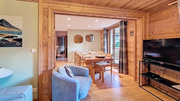 A wooden interior with a dining area, a TV, and a sofa. - Spacious apartment for 10, balcony, parking, near slopes (Saint-Martin-de-Belleville)