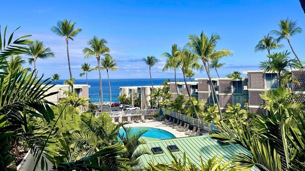 Ein Resort mit Pool, Palmen und Meerblick.