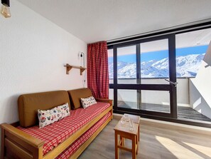 Relax in a serene room with a sofa, table, and stunning mountain views.