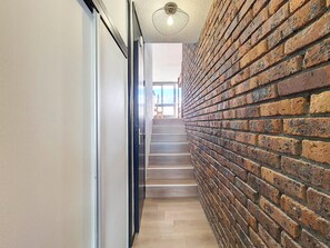 Stairs lead up to a bright, open area with a large window.