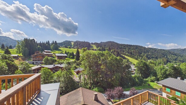 A residential area with houses, a wooden deck, and a clear sky.