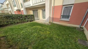 Un immeuble résidentiel doté d’une pelouse bien entretenue, d’une haie et d’une porte bien visible.