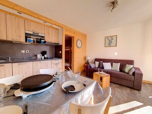 A compact living space with a kitchenette, dining area, and a sofa.