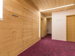 Ein Flur mit Holzwandverkleidung, einem roten Teppich und einem Schild, das die Zimmernummern 012 und 013 anzeigt.