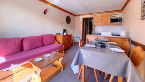 Ein gemütlicher, kompakter Wohnbereich mit Sofa, Esstisch und Küchenzeile.