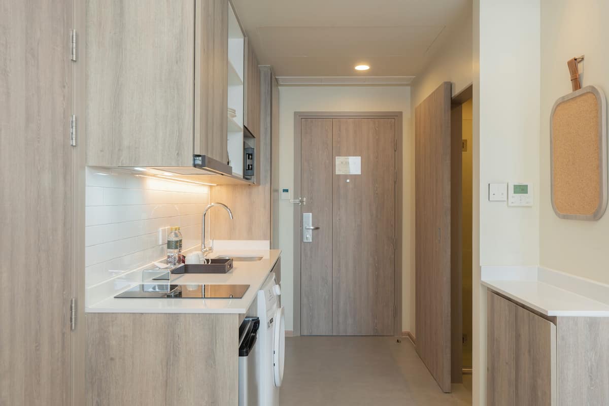 Una cocina moderna con armarios de madera, una encimera, un lavabo y una lavadora.